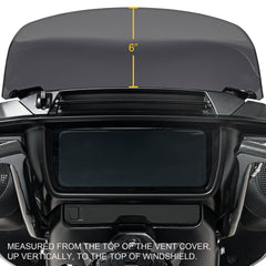 Measurement of a vent cover to the top of a windshield using a tape measure.